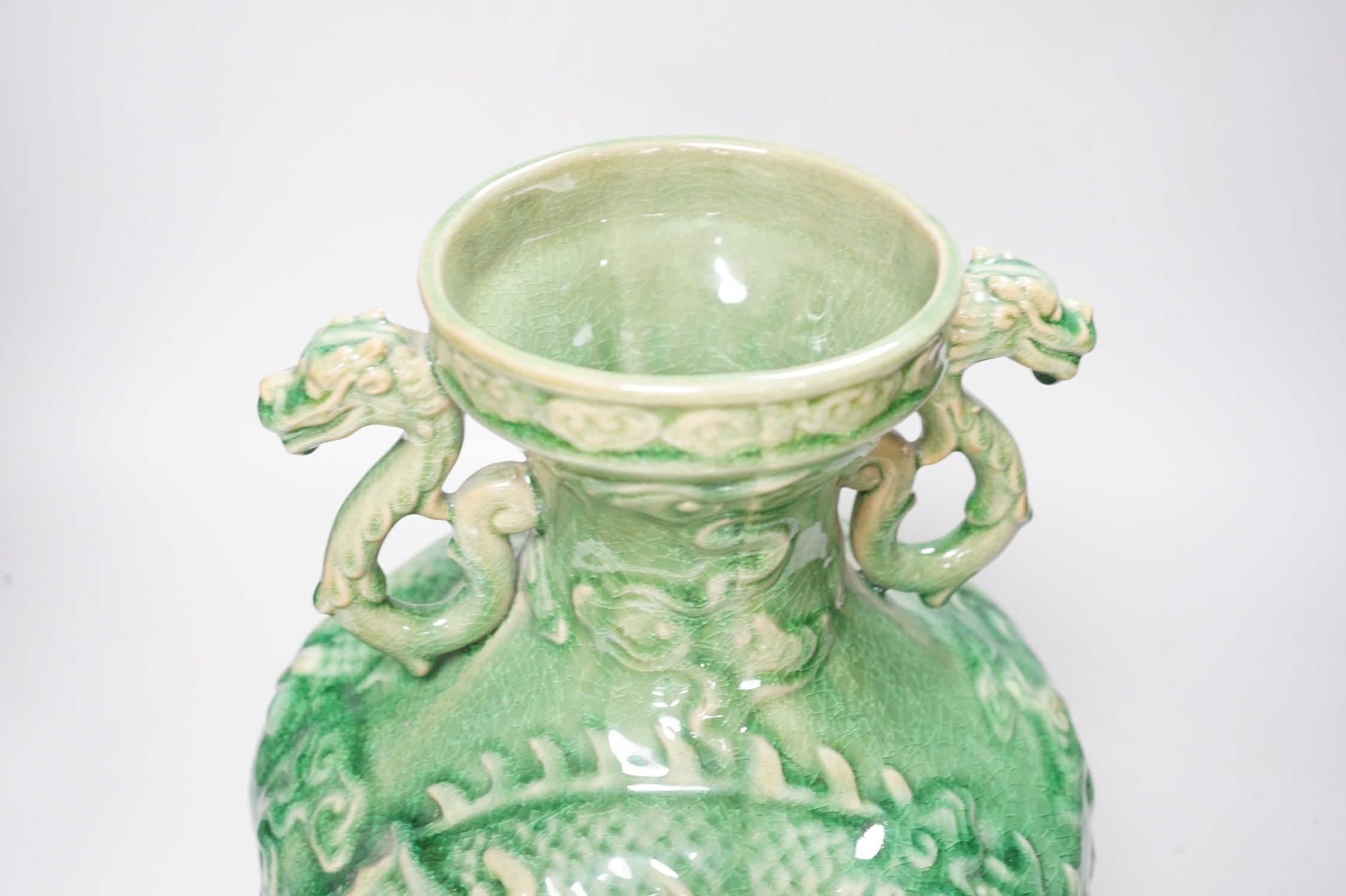 A Chinese green glazed vase with twin zoomorphic handles, decorated in relief with dragons, 35cm high